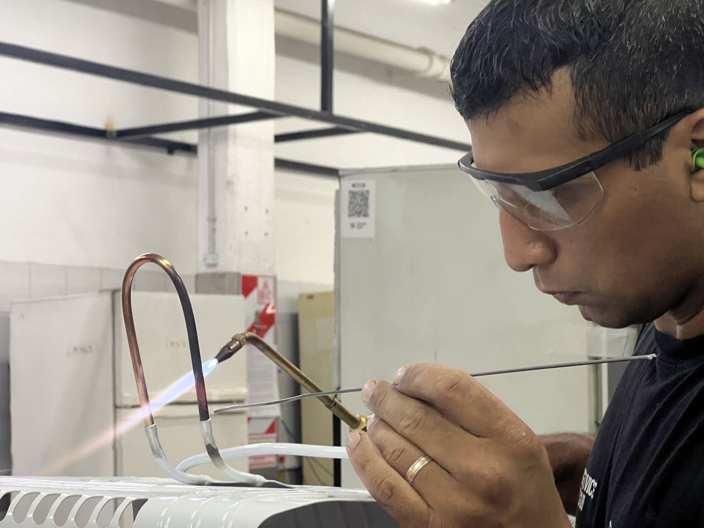 Técnico soldando la cañería de una heladera